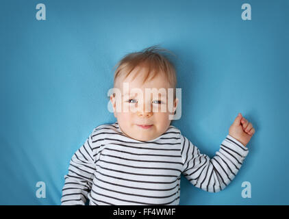 kleiner Junge auf blaue Decke Hintergrund Stockfoto