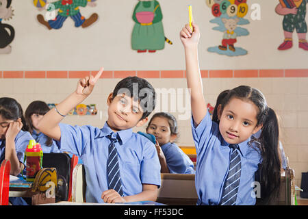Arm Arme Asien Asiatische Asiaten Kleidung Bänke Bücher fröhliche Heiterkeit Klassenzimmer Szene Klassenzimmer Szenen Kleidung Farben Stockfoto