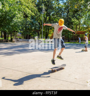 Springt der junge reitet auf einem Skateboard, Übungen Stockfoto