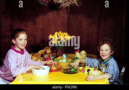 Tradition / Folklore, Ostern, Junge und Mädchen, sitzen am Tisch, Ostereier färben, Zusatzrechte-Clearences-nicht vorhanden Stockfoto