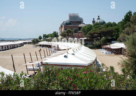 Der lange Sandstrand mit Chalets gegenüber vom Palazzo del Cinema del Lido di Venezia am Lungomare Guglielmo Marconi, Lido Stockfoto