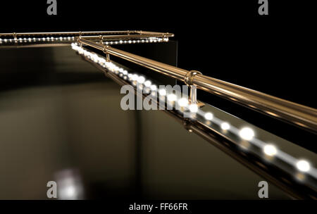 Eine regelmäßige leeren Stripperin Bühne mit einem Bronze Geländer und einen Streifen der Lichter auf einem dunklen Hintergrund Stockfoto