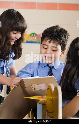 Asien Asiatische Asiaten Bänke fröhlich Frohsinn Kindheit Kinder Klassenzimmer Szene Klassenzimmer Szenen Closeup Kleidung Farben Stockfoto