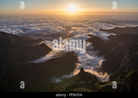 Blick vom Pico Ariero am Sonnenaufgang über zerklüftete Täler und tiefe Schluchten an der Nordküste von Madeira mit Wolken bedeckt Stockfoto
