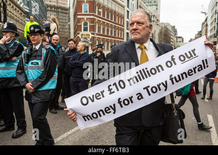 Einige Demonstranten halten Plakate als der Sarg der Baronin Thatcher verläuft entlang der Fleet Street auf dem Weg nach St. Pauls Cathedral.  Bevor ihr Begräbnis stattfand. 17. April 2013. London, Vereinigtes Königreich. Stockfoto