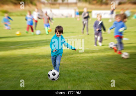 Gruppe von Kindern, Fußball spielen, üben im Freien, radiale Unschärfe angewendet Stockfoto