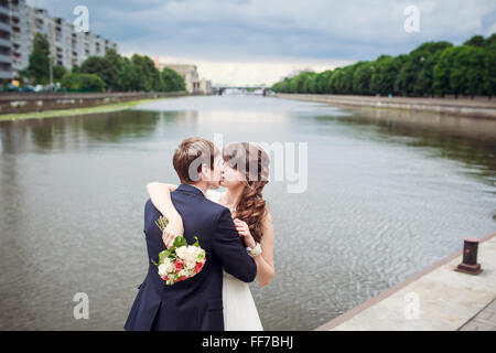 Braut und Bräutigam umarmt am Ufer in Ihrem Hochzeitstag Stockfoto