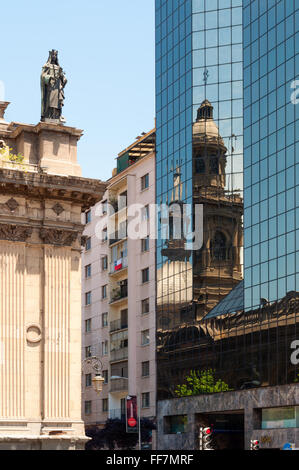 Die Iglesia Kathedrale in der Plaza de Armas, Santiago Chile spiegelt sich in der Glasfassade eines modernen Bürogebäudes. Stockfoto