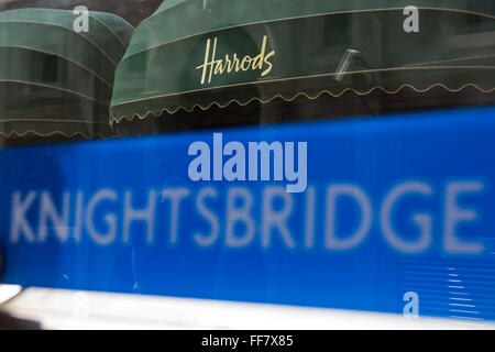 Knightsbridge London Underground Schild vor dem Eingang der Tube Station mit der Welt berühmten Harrods Shop Markise im Hintergrund, London, Vereinigtes Königreich. Stockfoto