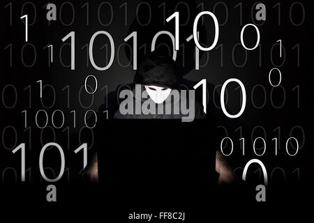 Ein maskierter Mann auf einen Laptop als Symbol für die Gefahren des Internets. Stockfoto