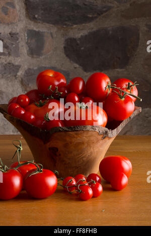 Holzschale Tomaten auf einem Tisch in einer rustikalen Küche Stockfoto