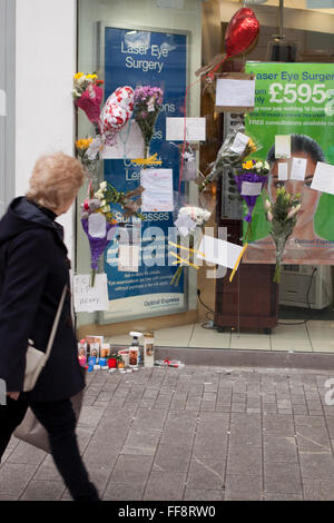 Donegall Place, Belfast, 11. Februar 2016. Eine Frau geht Vergangenheit Ort wo Mann obdachlos Belfast "Jimmy" starb am Sonntag früh Morning.Tributes von Blumen, Karten und Kerzen blieben am Tatort Credit: Bonzo/Alamy Live News Stockfoto