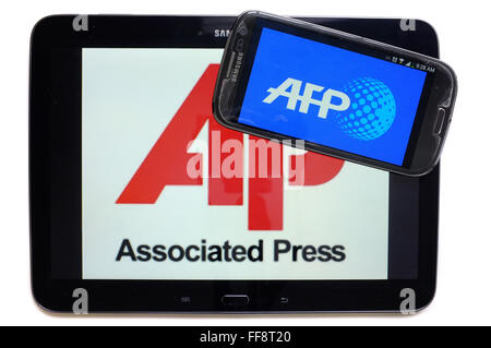 Die Nachrichtenagenturen AFP und AP auf den Bildschirmen der ein Tablet und Smartphone vor weißem Hintergrund fotografiert. Stockfoto