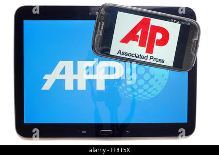 Das AP-Logo auf einem Smartphonebildschirm auf einem Tablet mit dem AFP-Logo auf weißem Hintergrund fotografiert. Stockfoto