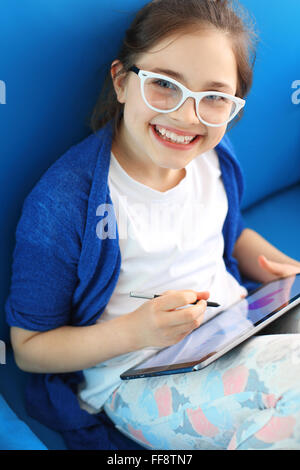 Kind spielt mit Tablet. Internet-Spiel-Unterhaltung in ihrer Freizeit Stockfoto