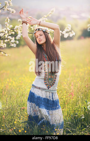 Wunderschöne Hippie-Frau tanzt in einer Sommerwiese. Freiheit und Harmonie Stockfoto