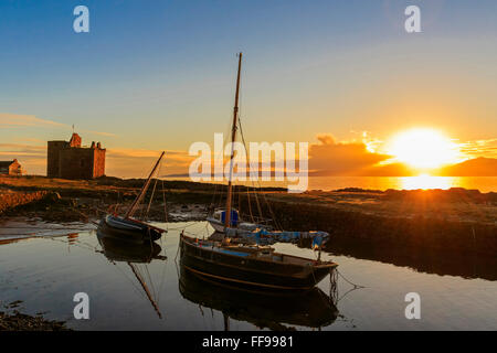 Portencross Burg, Firth of Clyde, Vereinigtes Königreich. 11. Februar 2016. Nach einem kalten und frostigen Februartag erlaubt der klare Himmel für einen malerischen Sonnenuntergang über der Isle of Arran und den Firth of Clyde mit dem Sonnenuntergang reflektieren Portencross Burg und die kleine Boote im Hafen. Bildnachweis: Findlay/Alamy Live-Nachrichten Stockfoto