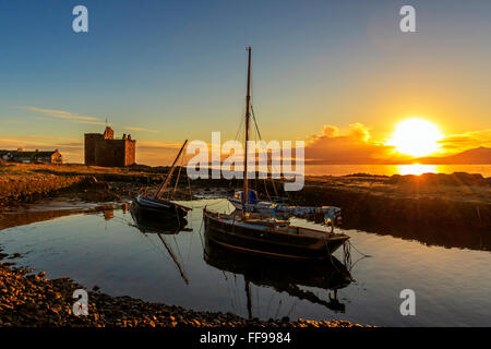 Portencross Burg, Firth of Clyde, Vereinigtes Königreich. 11. Februar 2016. Nach einem kalten und frostigen Februartag erlaubt der klare Himmel für einen malerischen Sonnenuntergang über der Isle of Arran und den Firth of Clyde mit dem Sonnenuntergang reflektieren Portencross Burg und die kleine Boote im Hafen. Bildnachweis: Findlay/Alamy Live-Nachrichten Stockfoto