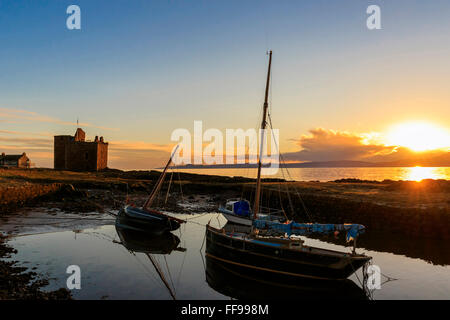 Portencross Burg, Firth of Clyde, Vereinigtes Königreich. 11. Februar 2016. Nach einem kalten und frostigen Februartag erlaubt der klare Himmel für einen malerischen Sonnenuntergang über der Isle of Arran und den Firth of Clyde mit dem Sonnenuntergang reflektieren Portencross Burg und die kleine Boote im Hafen. Bildnachweis: Findlay/Alamy Live-Nachrichten Stockfoto