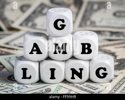 Acht weiße Würfel gelegt auf Haufen Geld Glücksspiel Wort Stockfoto