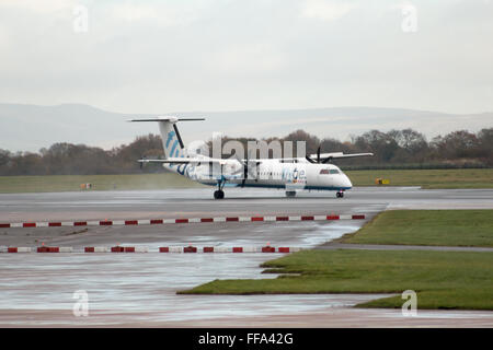 Flybe Bombardier Dash 8 Q400 regionale Turboprop Passagierflugzeug (G-ECOR) auf Manchester Flughafen-Startbahn rollen. Stockfoto