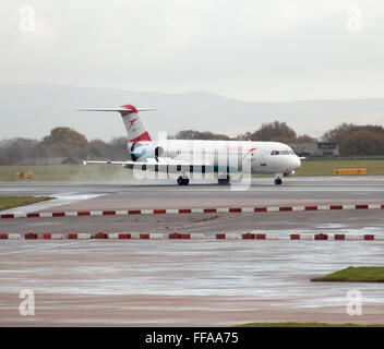 Austrian Airlines Fokker 100 mittelständische Twin-Turbinen-Kreiselbegläse Passagierflugzeug auf Manchester International Airport Asphalt Rollen. Stockfoto