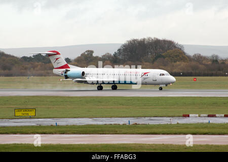 Austrian Airlines Fokker 100 mittelständische Twin-Turbinen-Kreiselbegläse Passagierflugzeug auf Manchester International Airport Asphalt Rollen. Stockfoto