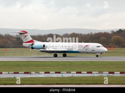 Austrian Airlines Fokker 100 mittelständische Twin-Turbinen-Kreiselbegläse Passagierflugzeug auf Manchester International Airport Asphalt Rollen. Stockfoto