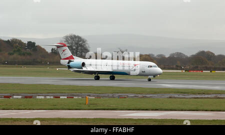 Austrian Airlines Fokker 100 mittelständische Twin-Turbinen-Kreiselbegläse Passagierflugzeug auf Manchester International Airport Asphalt Rollen. Stockfoto