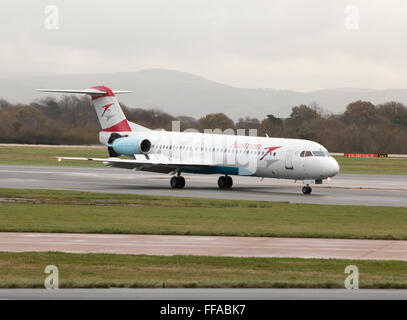 Austrian Airlines Fokker 100 mittelständische Twin-Turbinen-Kreiselbegläse Passagierflugzeug auf Manchester International Airport Asphalt Rollen. Stockfoto