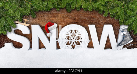 Schnee-Schriftzug Xmas Dekoration mit Tannenzweigen auf hölzernen Hintergrund Stockfoto