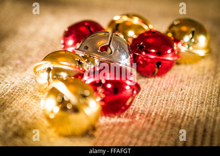 Verschiedene Größe und unterschiedliche farbige Jingle Weihnachtskugeln auf einem hessischen Tuch gelegt Stockfoto