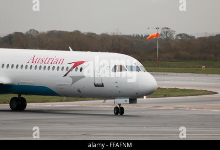 Austrian Airlines Fokker 100 mittelständische Twin-Turbinen-Kreiselbegläse Passagierflugzeug auf Manchester International Airport Asphalt Rollen. Stockfoto