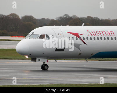 Austrian Airlines Fokker 100 mittelständische Twin-Turbinen-Kreiselbegläse Passagierflugzeug auf Manchester International Airport Asphalt Rollen. Stockfoto