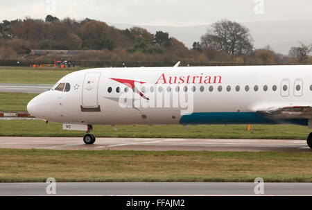 Austrian Airlines Fokker 100 mittelständische Twin-Turbinen-Kreiselbegläse Passagierflugzeug auf Manchester International Airport Asphalt Rollen. Stockfoto