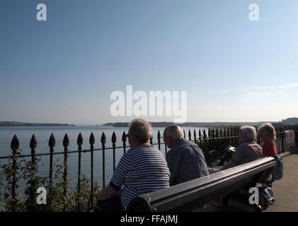 Rentner sitzen auf einer Bank, genießen den Blick auf das Meer in Tenby Pembroke Wales Stockfoto