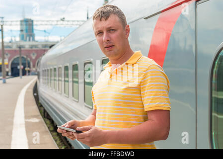 Mann in einem gelben Hemd am Bahnhof Stockfoto