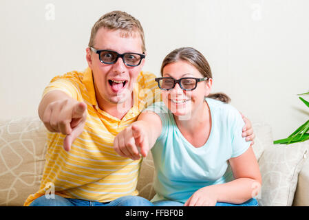 glückliches Paar in 3D Brille vor dem Fernseher zu Hause Stockfoto