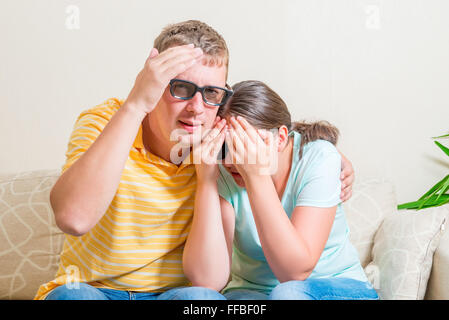 Mann und Frau auf der Couch vor dem 3D-Brille scary movie Stockfoto