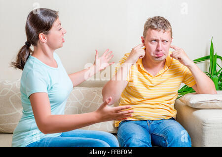 Frau schimpft mit ihr Mann sitzt auf einem Sofa im Wohnzimmer Stockfoto