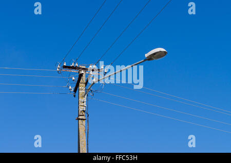 Laterne mit vielen elektrischen Leitungen gegen blauen Himmel Stockfoto