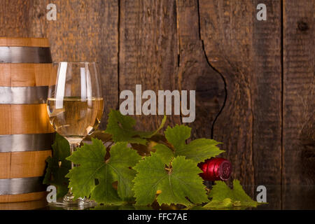 Glas Wein Flasche bedeckt mit grapeleaves Stockfoto