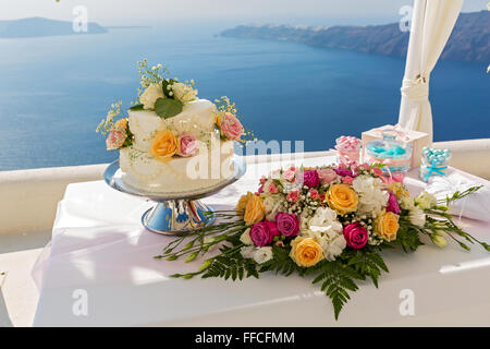 Hochzeitstorte und Blumensträuße auf den Tisch, gegen das Meer. Griechenland. Stockfoto