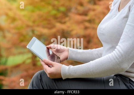 Frau mit einem Tablet-PC im Herbst park Stockfoto
