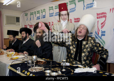 Während des jüdischen Festivals von Purim besucht eine Gruppe von orthodoxen jüdischen Jungen aus der Viznitz-Jeschiwa (Schule) verkleidet lokale Geschäftsleute, Geld für ihre Schule zu sammeln. Am Ende des Tages sie zurück zu ihrer Schule und haben ein Feier fest, führt die Purim Rabbiner ein Lied in seine Klasse während des Essens. Während des Festivals werden große Mengen von Alkohol konsumiert. Stockfoto