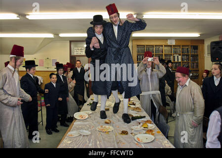 Während des jüdischen Festivals von Purim feiern eine Gruppe von orthodoxen jüdischen Jungen aus der Viznitz-Jeschiwa (Schule) im Kostüm des Festivals mit einem fest. Am Abend fährt schnell auf tanzen auf den Tischen, die fliegen überall Essen sendet. Die Schuljungen trinken große Mengen Alkohol während des Tages und der Nacht. Stockfoto
