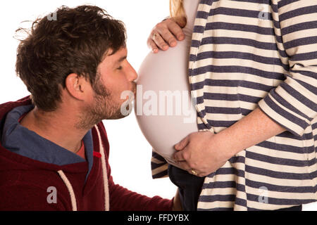 Mann küssen schwanger Frau Baby Bump-studio Stockfoto