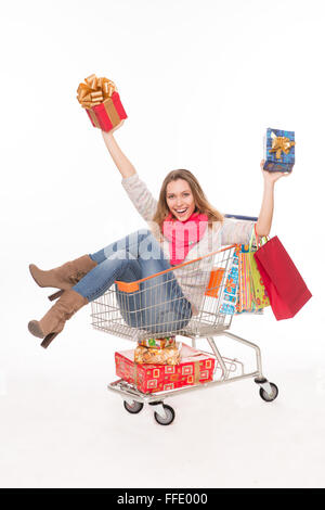 Glückliche Frau in Einkaufswagen mit präsentiert Stockfoto