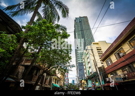 Palmen und Gebäude entlang M.F Jhocson Street, in Sampaloc, Manila, Philippinen. Stockfoto