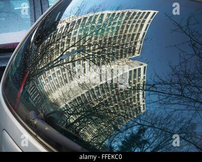 Alte hohe Gebäude mit Wohnungen spiegeln sich im Fenster eines Autos in der ehemaligen DDR-Teil der Stadt in der Mitte Berlins auf 21. Dezember 2015. Foto: Wolfram Steinberg/dpa Stockfoto